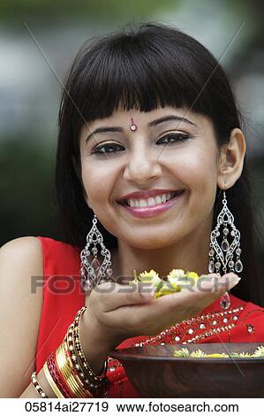 Head shot of Indian woman smiling and holding flowers View Large Photo Image Stock Photo - Head shot of Indian woman smiling and holding flowers. Fotosearch