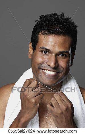 Picture - head shot of man smiling holding dental floss. Fotosearch