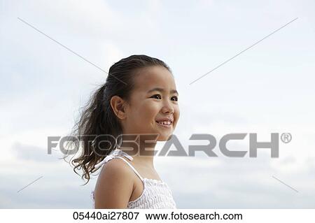head shot of young girl smiling with clouds in background View Large Photo Image Stock Photo - head shot of young girl smiling with clouds in background. Fotosearch