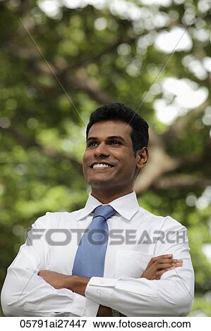 Indian man looking up and smiling with folded arms View Large Photo Image Stock Photo - Indian man looking up and smiling with folded arms. Fotosearch