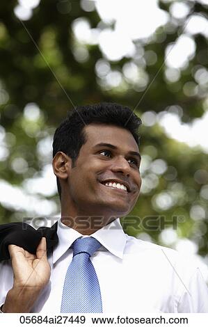 Stock Photo - Indian man smiling and looking away. Fotosearch