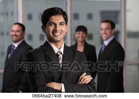 Stock Photo - Indian man smiling in front of his colleagues. Fotosearch
