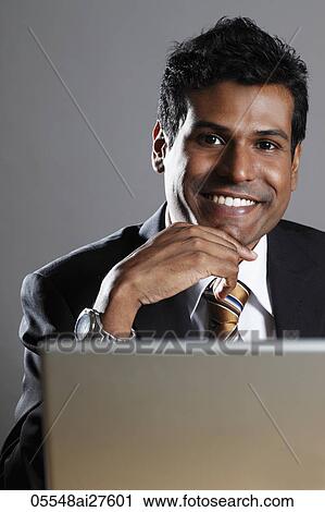 Indian man smiling with laptop View Large Photo Image Stock Image - Indian man smiling with laptop. Fotosearch