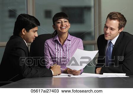 Stock Image - Indian woman laughing with Caucasian and Indian colleagues. Fotosearch