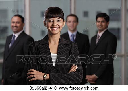 Indian woman smiling with arms folded in front of male colleagues View Large Photo Image Stock Image - Indian woman smiling with arms folded in front of male colleagues. Fotosearch