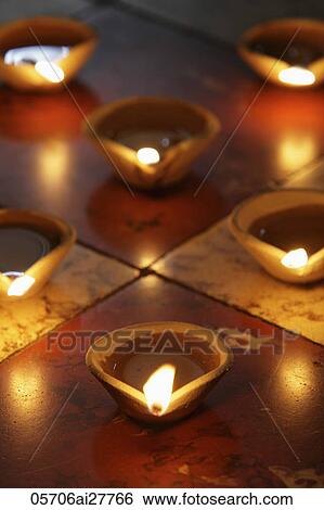 Stock Photograph - Lit clay oil lamps on floor. Fotosearch