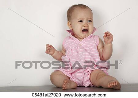 Stock Image - mixed raced baby sitting on floor and crying. Fotosearch