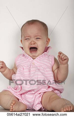 Stock Image - mixed raced baby sitting on floor and crying. Fotosearch