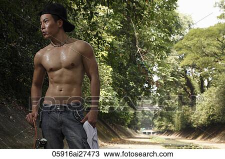 Shirtless Chinese man holding skateboard outside in park View Large Photo Image Stock Image - Shirtless Chinese man holding skateboard outside in park. Fotosearch