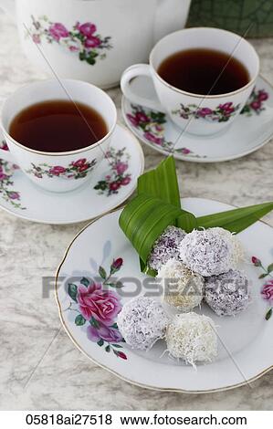 Stock Photo - Tea and coconut sweets on china plates.. Fotosearch