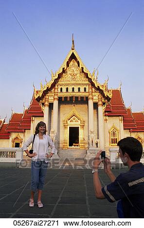 Stock Image - Thailand, Bangkok, Tourist Couple Taking Photos in Wat Po. Fotosearch