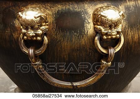 Two faces on giant bronze urn View Large Photo Image Picture - Two faces on giant bronze urn. Fotosearch