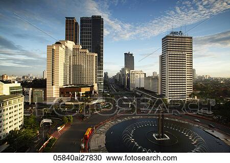 Stock Image - View of the Hotel Indonesia roundabout, Welcome Monument and buildings along Jalan Thamrin, Jakarta. Fotosearch