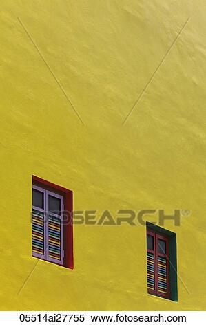 Stock Photography - Yellow painted wall with bright colored windows. Fotosearch