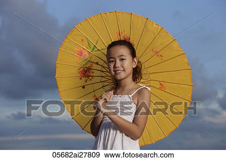 young girl holding yellow Chinese umbrella and smiling View Large Photo Image Stock Photo - young girl holding yellow Chinese umbrella and smiling. Fotosearch