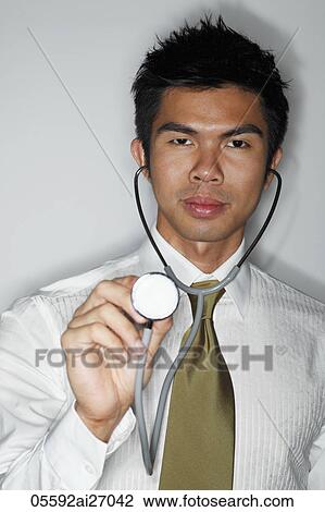 young male doctor holding stethoscope View Large Photo Image Stock Image - young male doctor holding stethoscope. Fotosearch