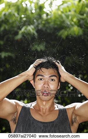 Stock Image - young man covered in water with hands in hair. Fotosearch