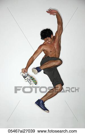 Stock Photo - young man jumping in air with skateboard. Fotosearch