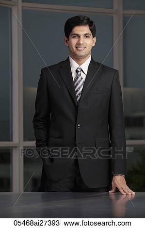 young man smiling and standing at desk View Large Photo Image Stock Image - young man smiling and standing at desk. Fotosearch