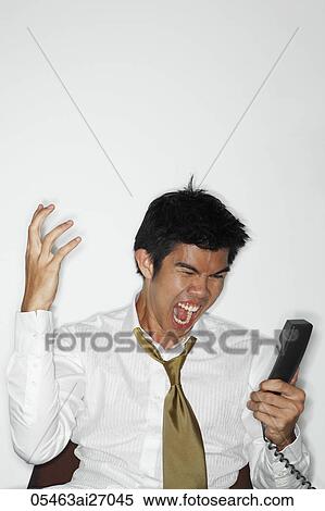 Stock Photography - young man yelling at phone. Fotosearch