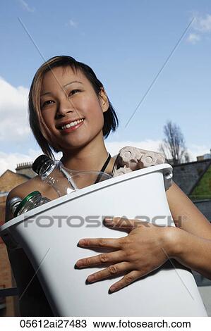 Young woman holding rubbish bin for recycling View Large Photo Image Stock Image - Young woman holding rubbish bin for recycling. Fotosearch