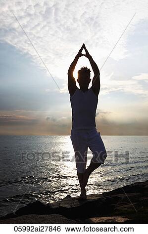 backlit image of man doing yoga next to ocean View Large Photo Image Stock Photograph - backlit image of man doing yoga next to ocean. Fotosearch