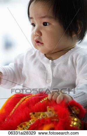 Chinese baby holding red toy View Large Photo Image Stock Photo - Chinese baby holding red toy. Fotosearch