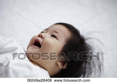 Stock Photo - Chinese baby laying on back smiling. Fotosearch