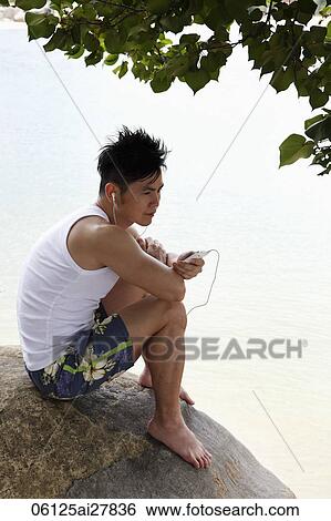Chinese man holding phone and listening to music View Large Photo Image Stock Photograph - Chinese man holding phone and listening to music. Fotosearch