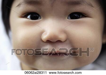 Stock Image - Close up of baby's face smiling. Fotosearch