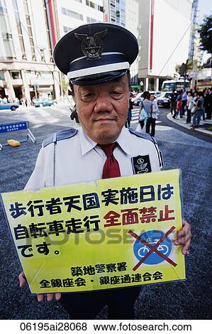 Enforcement Officer Holding No Cycling Sign. Japan, Tokyo, Ginza, View Large Photo Image Stock Photo - Enforcement Officer Holding No Cycling Sign. Japan, Tokyo, Ginza,. Fotosearch