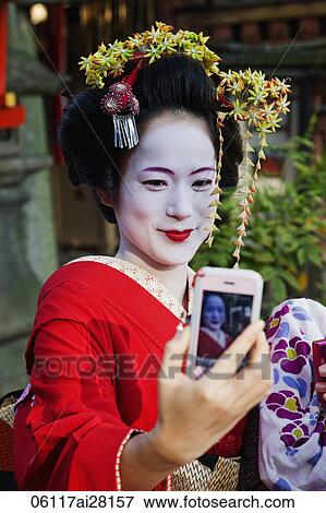 Geisha taking a photo of herself with her phone. View Large Photo Image Stock Photo - Geisha taking a photo of herself with her phone.. Fotosearch