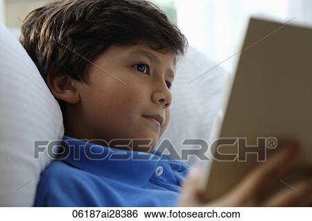 Head shot of young boy reading book View Large Photo Image Stock Photograph - Head shot of young boy reading book. Fotosearch