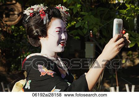 Japanese woman in traditional clothes taking a photo View Large Photo Image Stock Photo - Japanese woman in traditional clothes taking a photo. Fotosearch