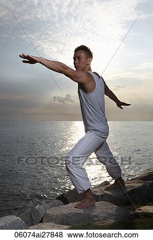 man doing yoga pose next to water View Large Photo Image Stock Photo - man doing yoga pose next to water. Fotosearch
