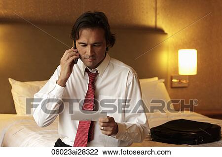 Man holding ticket and phone and frowning View Large Photo Image Stock Image - Man holding ticket and phone and frowning. Fotosearch
