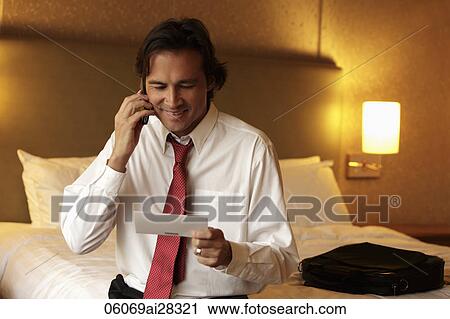 man holding ticket and smiling while talking on phone View Large Photo Image Stock Image - man holding ticket and smiling while talking on phone. Fotosearch