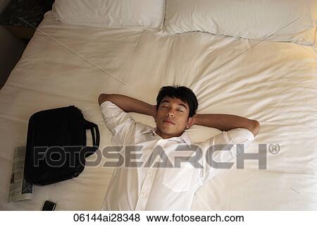 Man laying down on bed with eyes closed View Large Photo Image Stock Photo - Man laying down on bed with eyes closed. Fotosearch