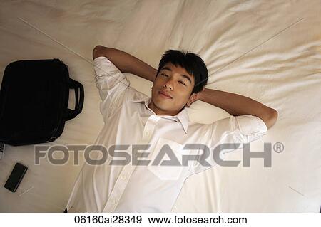 man laying on bed with hands behind his head. View Large Photo Image Stock Photo - man laying on bed with hands behind his head.. Fotosearch