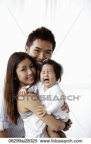 Mother and father holding crying baby View Large Photo Image Stock Photography - Mother and father holding crying baby. Fotosearch
