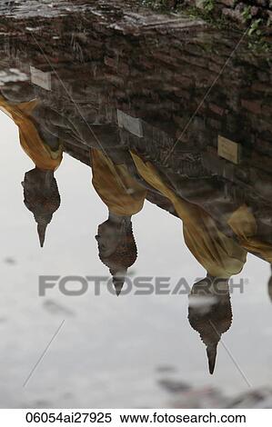 Stock Photography - Reflection of stone Buddhas in water. Fotosearch