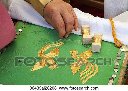 Stock Photo - Woman Embroidering Phoenix with gold thread, Seoul, Korea. Fotosearch