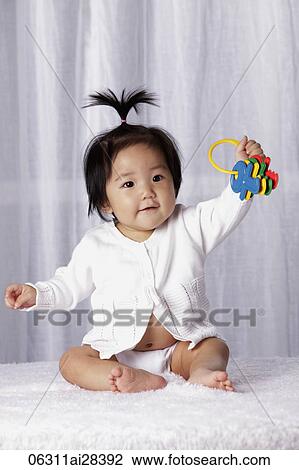 Young baby holding toy keys View Large Photo Image Stock Image - Young baby holding toy keys. Fotosearch