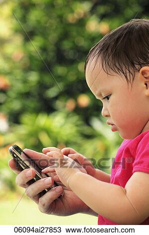 young girl playing with phone View Large Photo Image Stock Image - young girl playing with phone. Fotosearch
