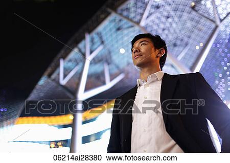 young man in suit standing in front of building at night View Large Photo Image Stock Image - young man in suit standing in front of building at night. Fotosearch