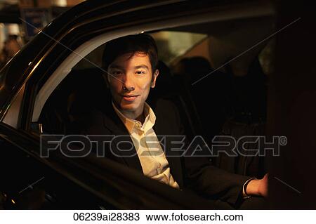 Young man sitting in car looking out of window at night View Large Photo Image Stock Image - Young man sitting in car looking out of window at night. Fotosearch