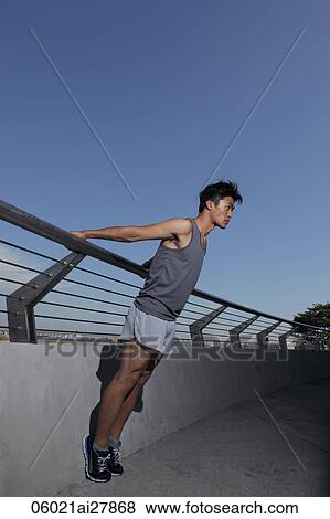 young man stretching near fence View Large Photo Image Stock Photo - young man stretching near fence. Fotosearch