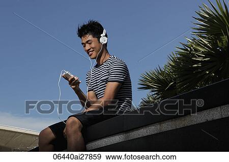 Young man wearing headphones and listening to music View Large Photo Image Stock Photo - Young man wearing headphones and listening to music. Fotosearch