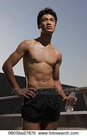 young man with shirt off holding water bottle View Large Photo Image Stock Photography - young man with shirt off holding water bottle. Fotosearch