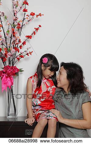 Chinese mother and daughter wearing Cheongsams looking at eachother View Large Photo Image Stock Photo - Chinese mother and daughter wearing Cheongsams looking at eachother. Fotosearch
